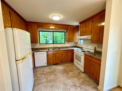 A kitchen with wooden cabinets and a white refrigerator.