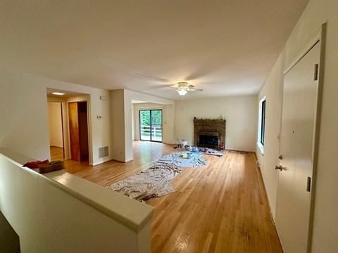 A living room with a fireplace and a rug on the floor.