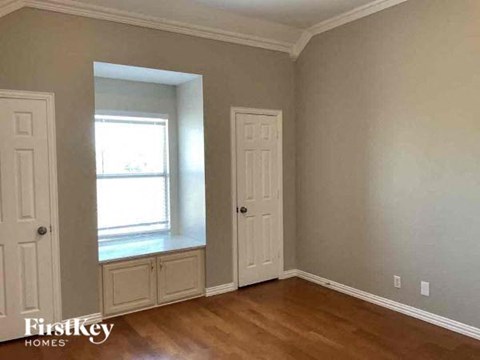 an empty room with a window and a white door