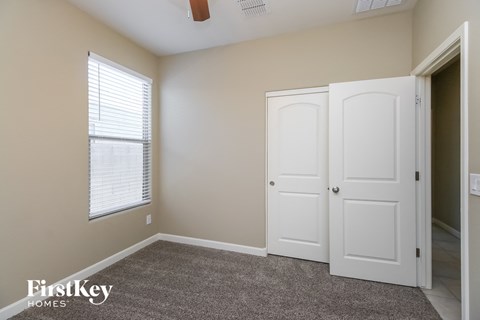 a bedroom with a closet and two doors and a window