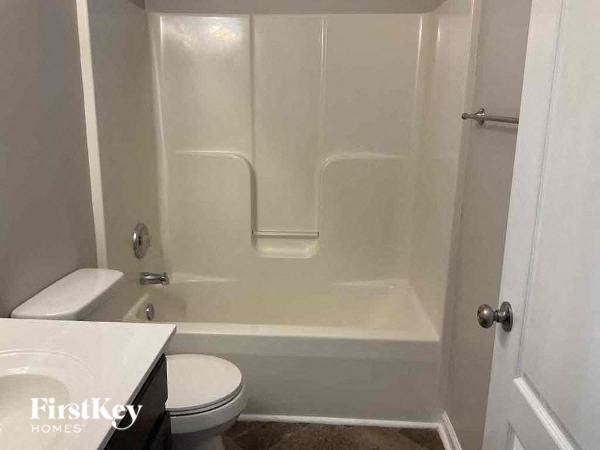 a white bathroom with a toilet and a bath tub