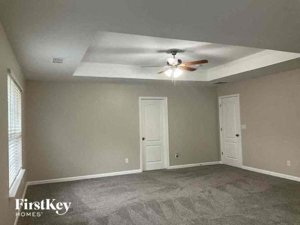 an empty living room with a ceiling fan