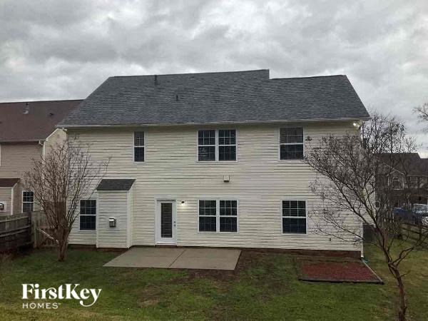 a white house with a gray roof on a cloudy day