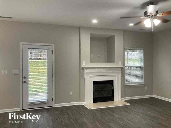 a living room with a fireplace and a ceiling fan