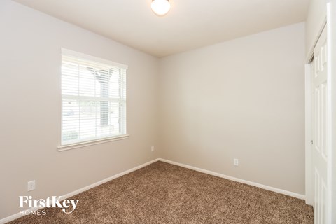 a bedroom with a carpeted floor and a window