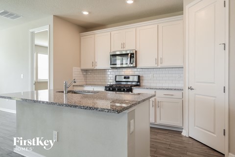 a kitchen with white cabinets and a granite counter top