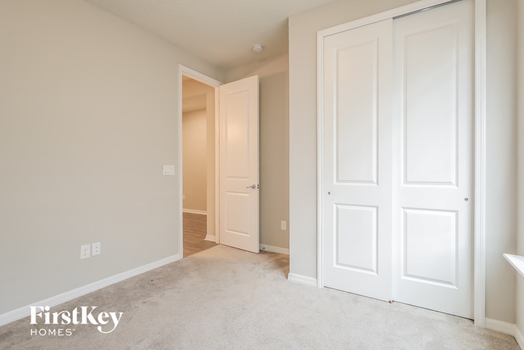 a bedroom with two closets and a door to a hallway