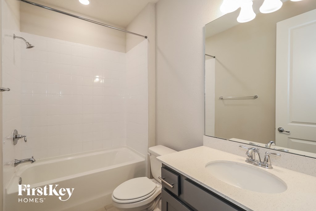 a bathroom with a sink toilet and shower and a mirror