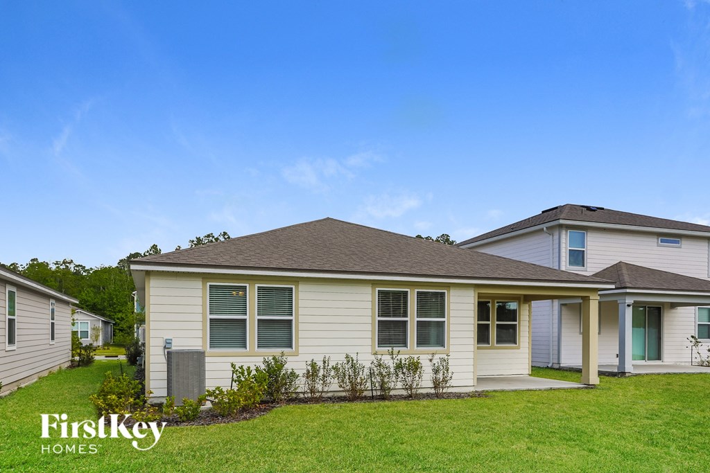 a white house with a lawn and a blue sky