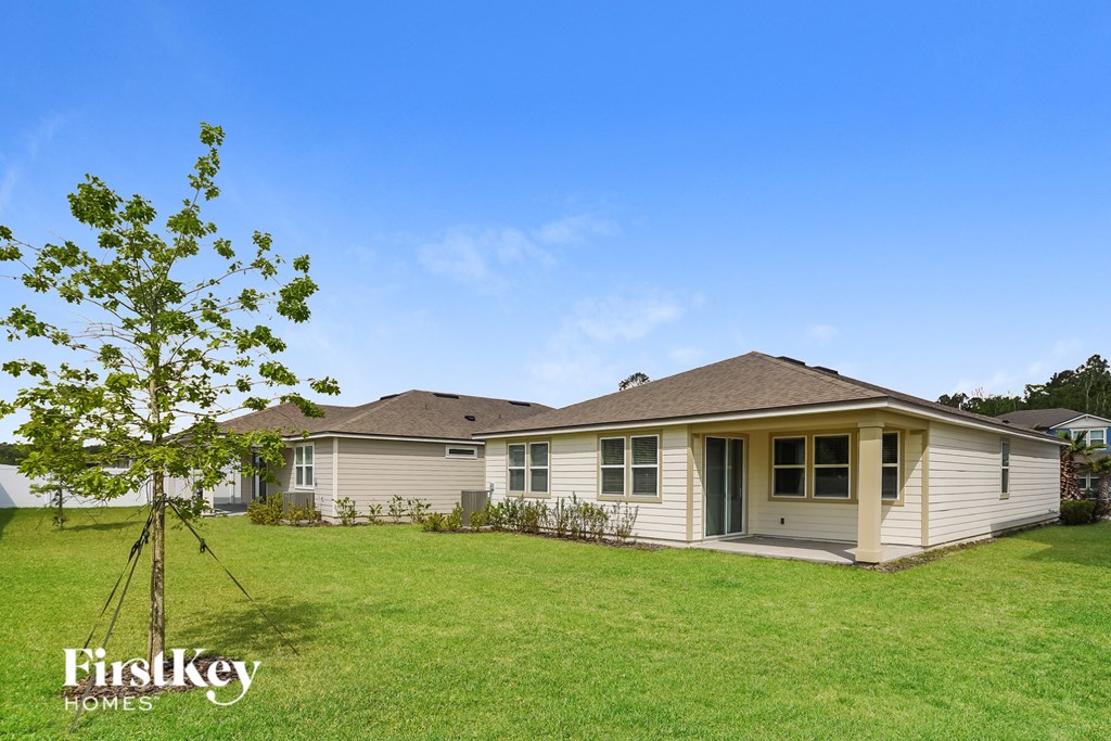 a white house with a small tree in the yard