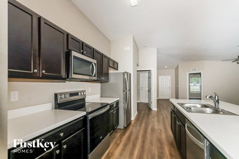a modern kitchen with black cabinets and stainless steel appliances