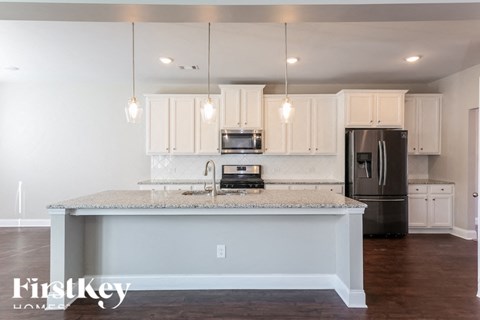 A kitchen with a granite countertop and a refrigerator.