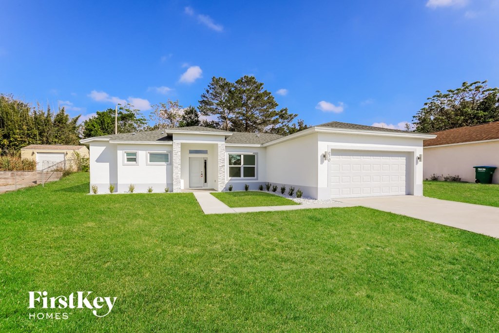 a white house with a lawn and a driveway