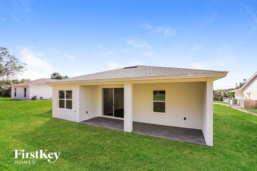 a small white house with a lawn and a grass covered