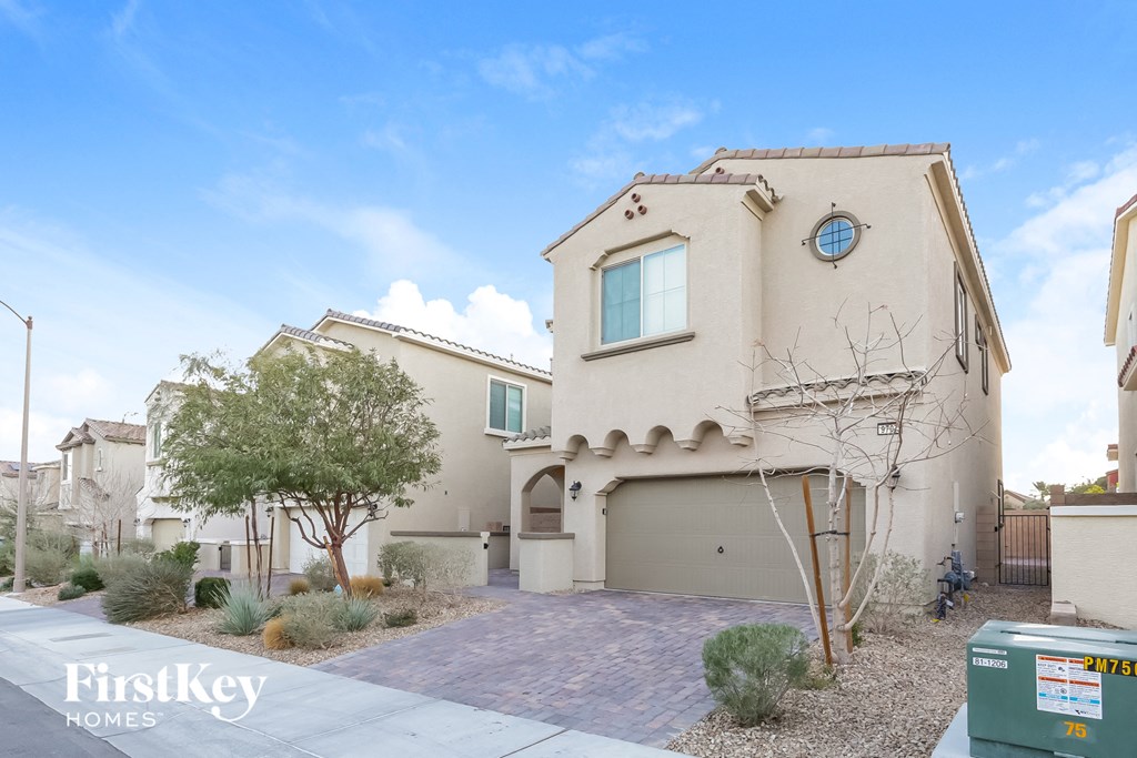 a beige house with a driveway and a garage door