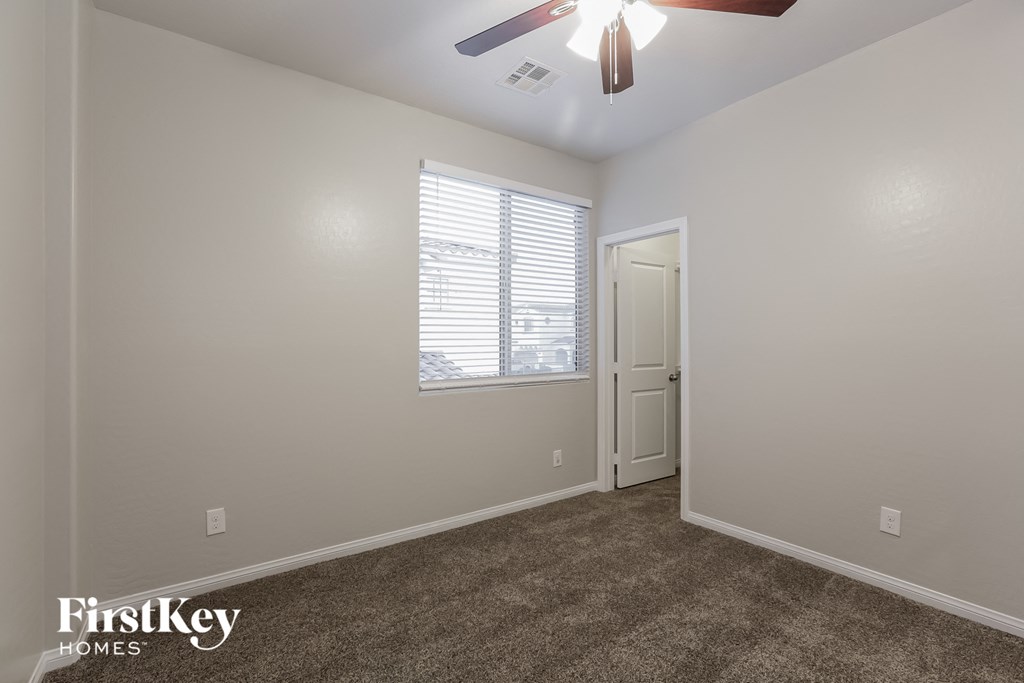 a living room with carpet and a ceiling fan