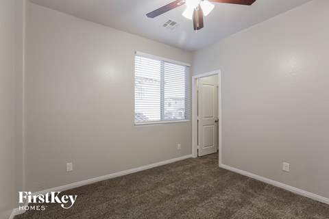 a living room with carpet and a ceiling fan