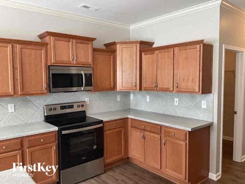 A kitchen with wooden cabinets and a stove top oven.