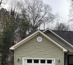 A small house with a garage door is for sale.