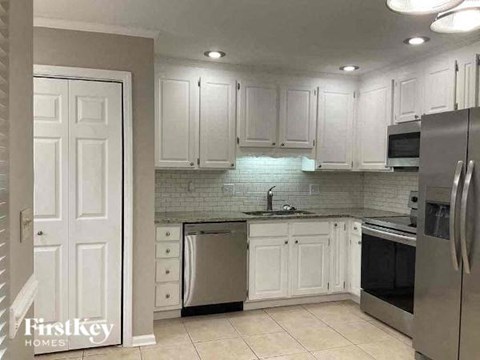 A kitchen with white cabinets and stainless steel appliances.