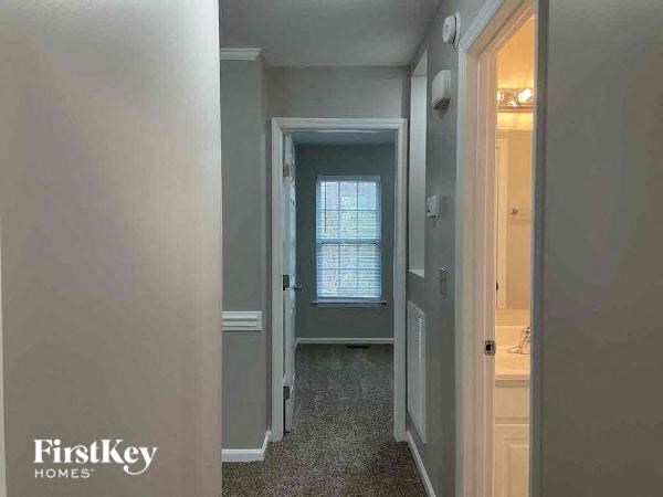 A hallway with a door on the right and a window on the left.