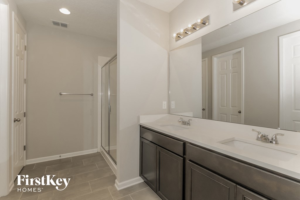 a bathroom with a large mirror and a sink and a shower