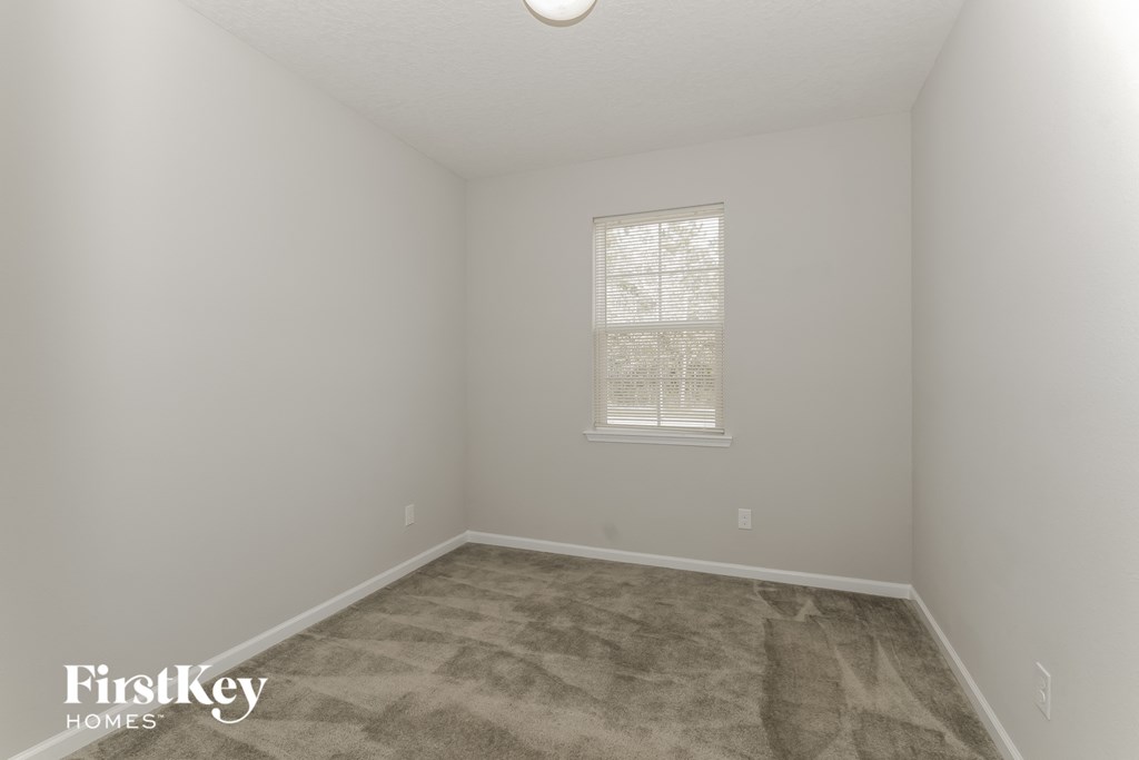 a bedroom with a carpeted floor and a window