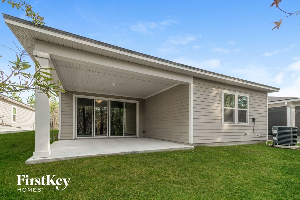 a remodeled house with a patio and a lawn