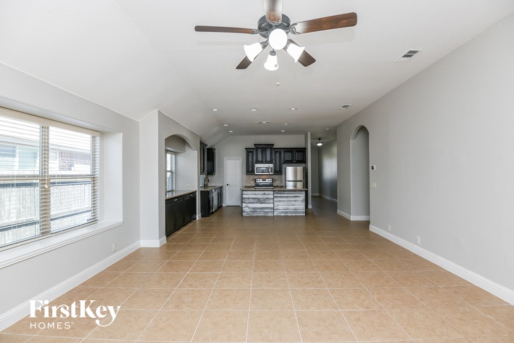 A spacious kitchen with a fan on the ceiling.