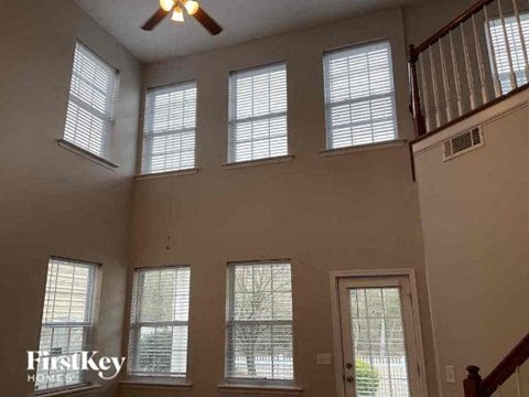 a living room with six windows and a ceiling fan