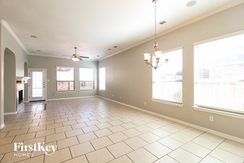 a dining room and living room with large windows and tiled flooring