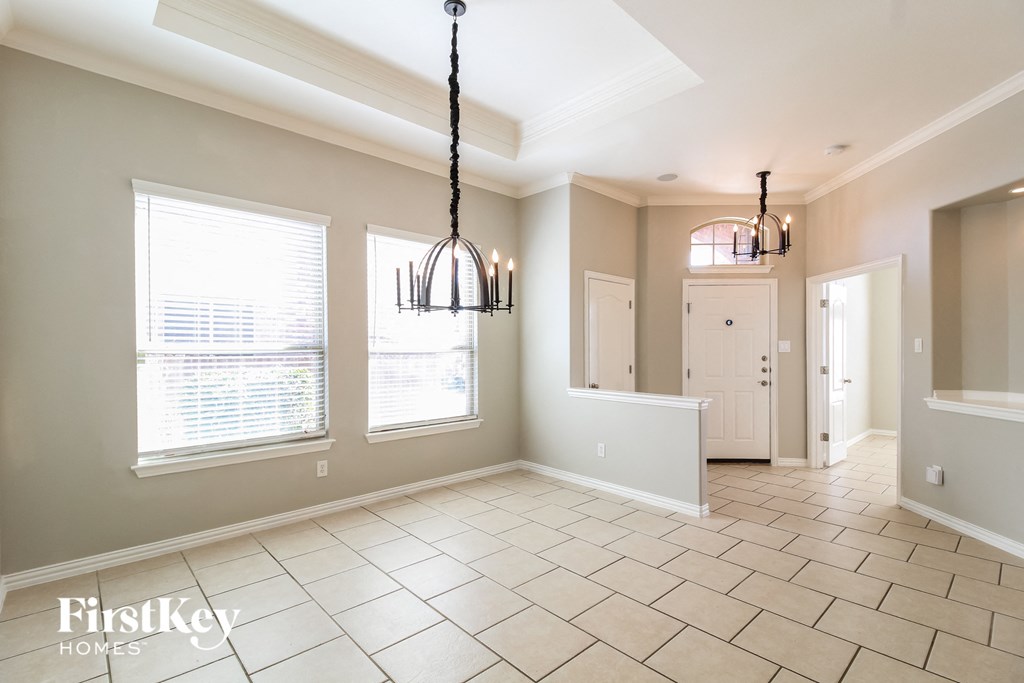 an empty dining room with two windows and a white door