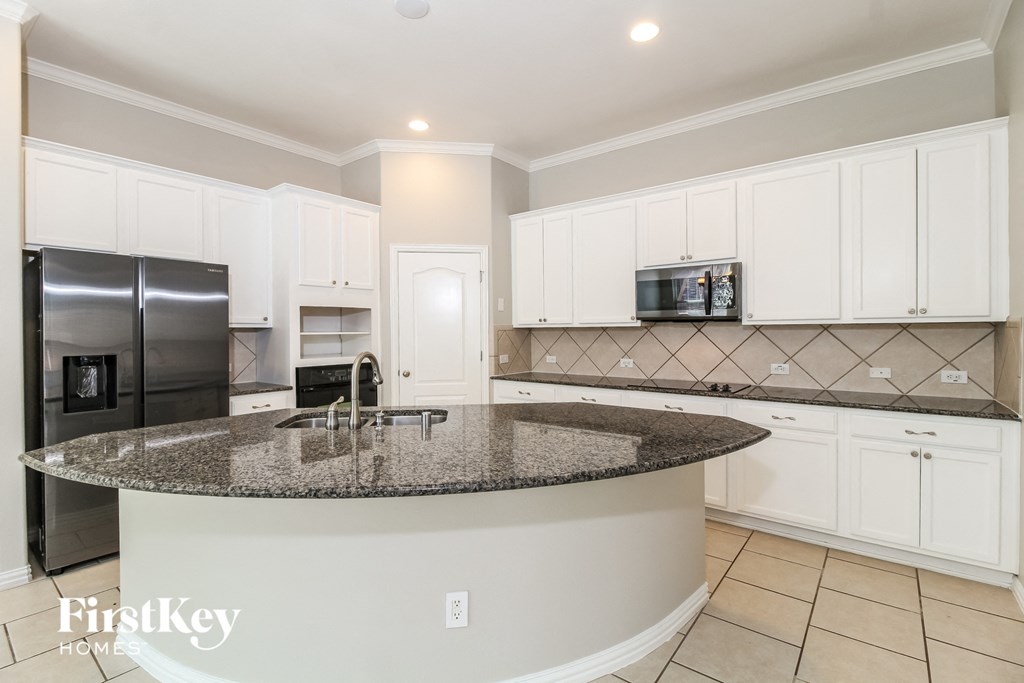 a kitchen with white cabinets and a granite counter top