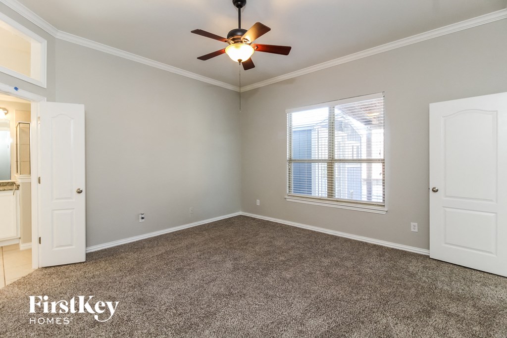 the living room of an empty house with a ceiling fan