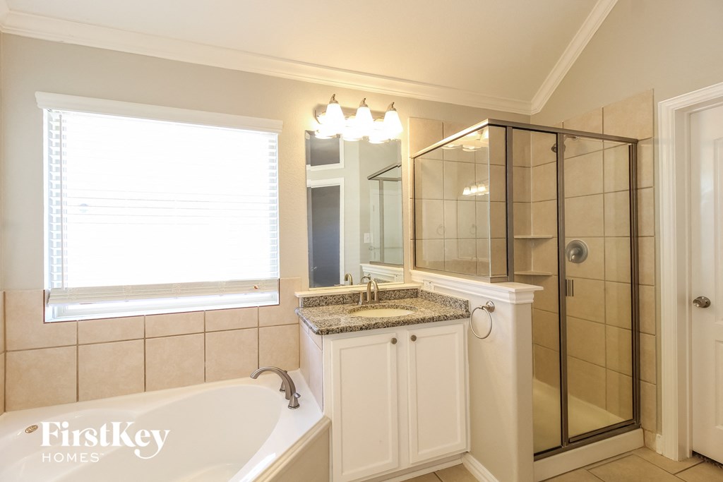 a bathroom with a tub and a shower and a sink