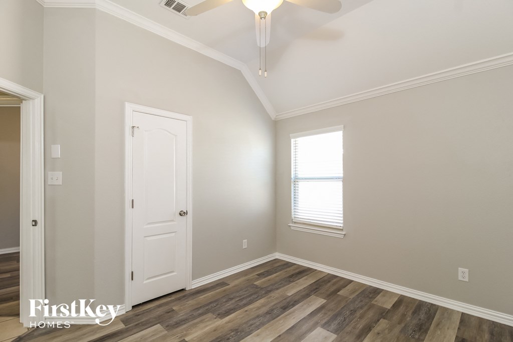 a bedroom with a white door and a ceiling fan
