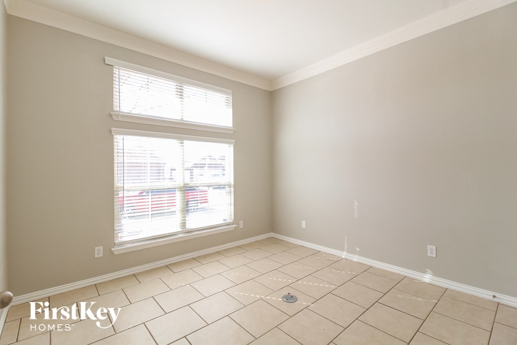 a living room with a large window and tiled flooring