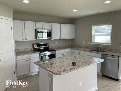 a kitchen with white cabinets and a granite counter top
