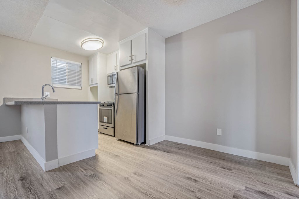 a kitchen with an island and a stainless steel refrigerator