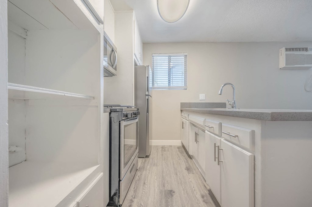 a kitchen with white cabinets and stainless steel appliances