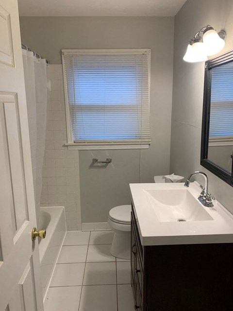 A white sink in a bathroom with a white toilet and a white door.