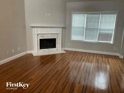 a living room with a fireplace and wooden floors