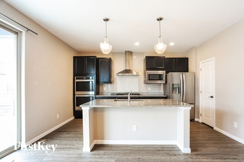 a kitchen with black appliances and a large counter top