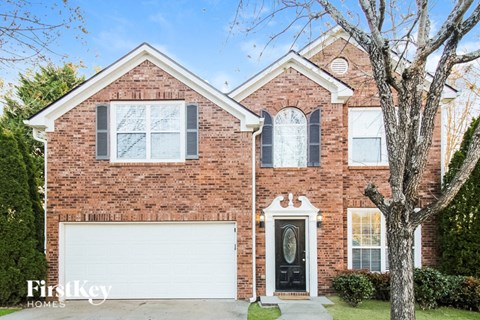 A brick house with a white garage door and a black front door.