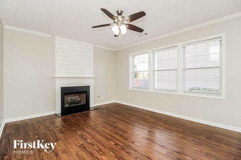 A room with a fireplace and a ceiling fan.