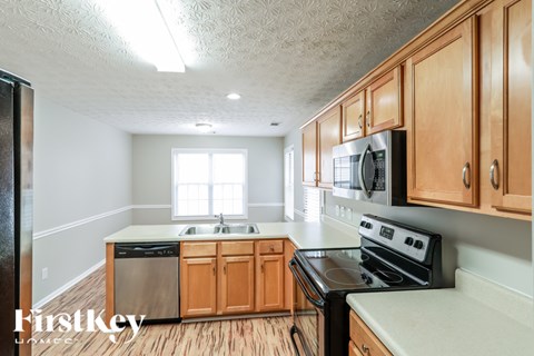 A kitchen with wooden cabinets and a stove top oven.