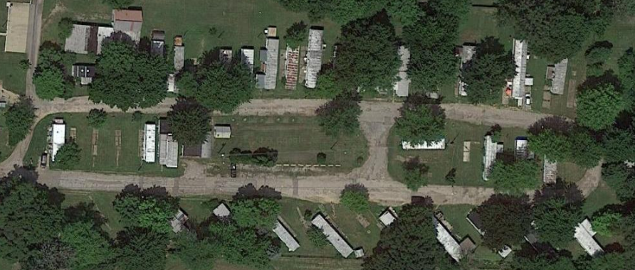 an aerial view of a cemetery with houses and trees
