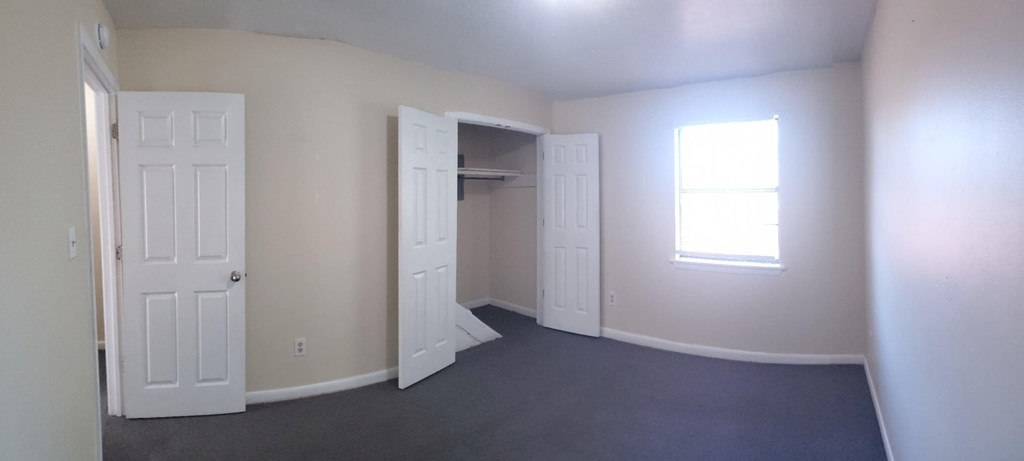 A room with a door, a window, and a closet.