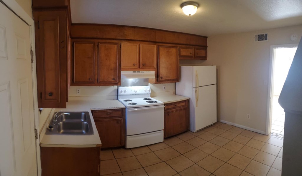 A kitchen with wooden cabinets and white appliances.