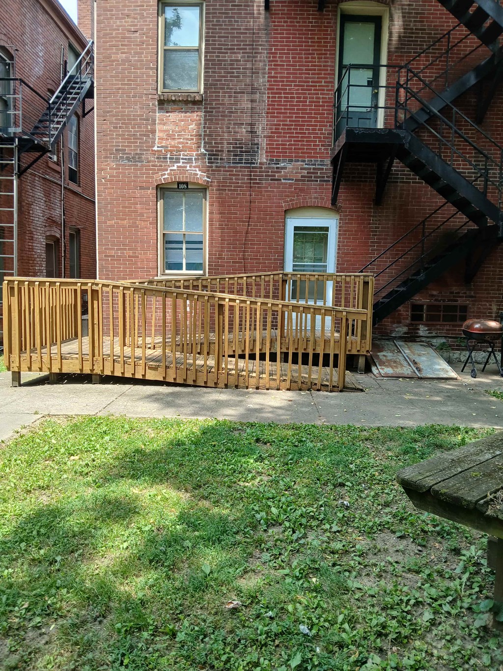 a wooden deck in front of a brick building
